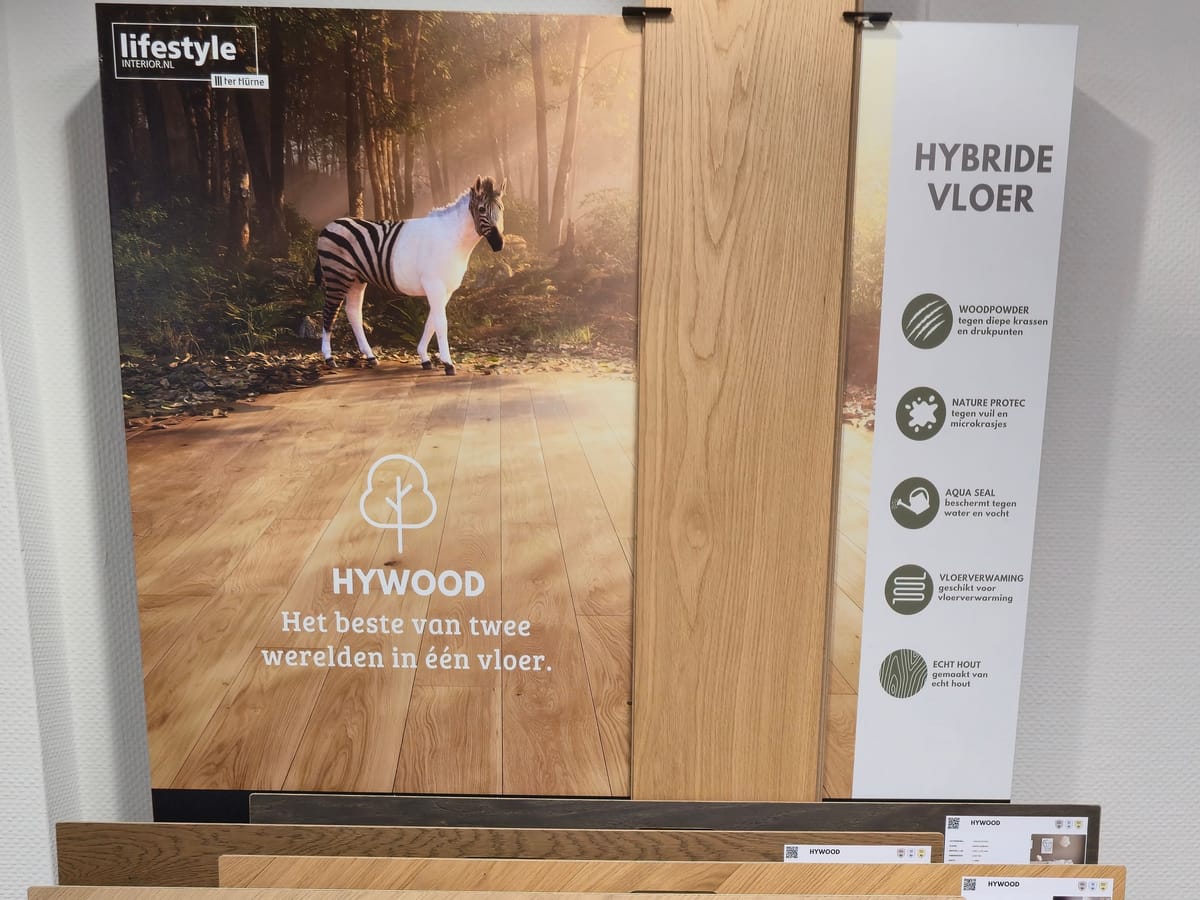 Het paneel van Hywood, de hybride houtvloer, in de winkel, met een lange plank als staal en vloerstalen eronder