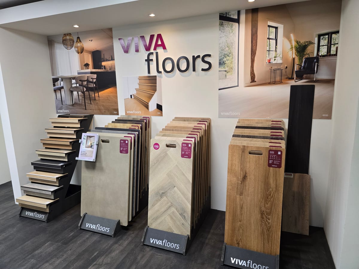 Hoek van Vivafloors in de winkel met rekken vol vloerstalen, de demotrap en sfeerfoto's aan de wand