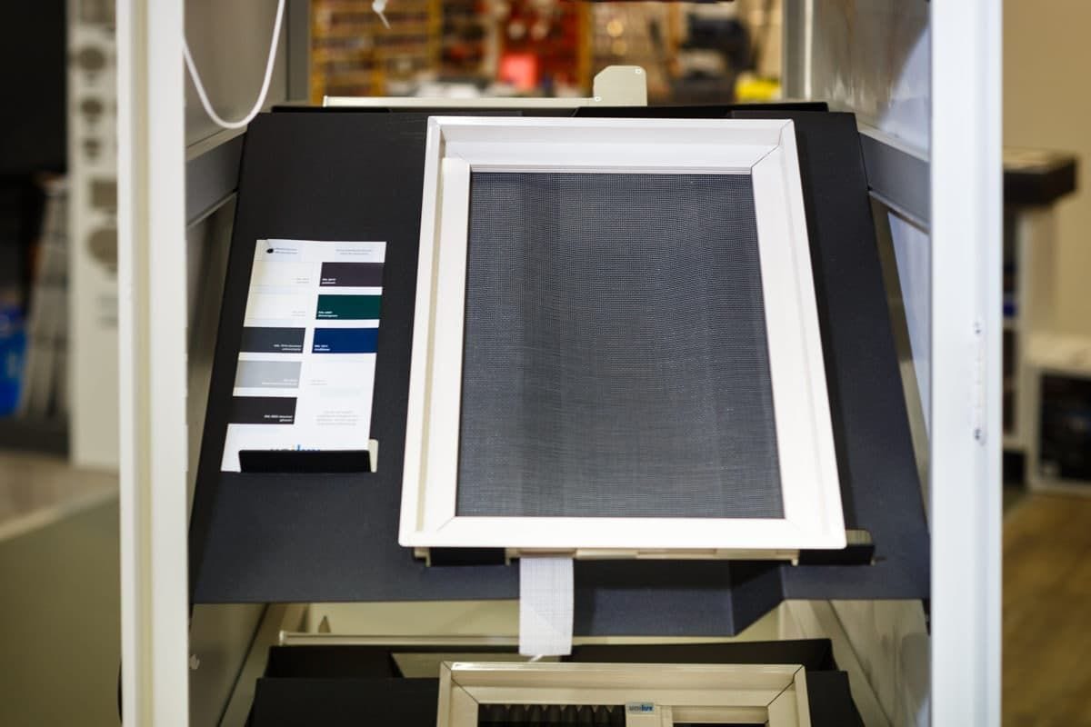 Inzethor met gaas in een wit frame, opgesteld in de showroom